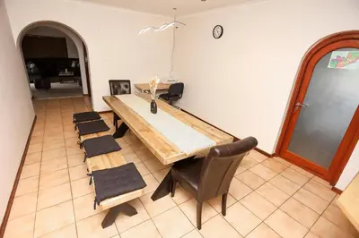 a dining room with a wooden table and chairs at African Oasis Zambia in Somerset West