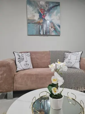 a living room with a couch and a table with flowers at Cosy Apartment at Sitari Country Estate - Somerset West in Croydon
