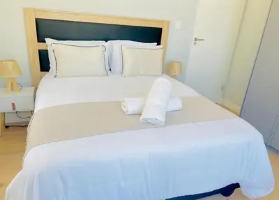 a large white bed with two rolled towels on it at Cosy Apartment at Sitari Country Estate - Somerset West in Croydon