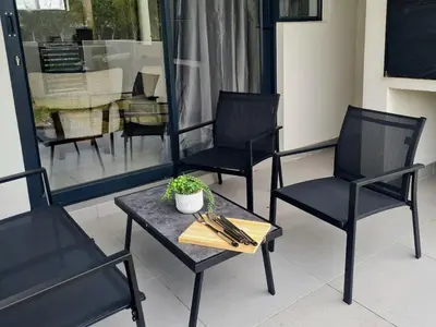 three black chairs and a table and a table and chairs at Cosy Apartment at Sitari Country Estate - Somerset West in Croydon
