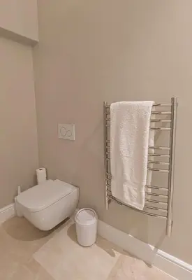 a bathroom with a toilet and a towel rack at Fifty9 in Somerset West