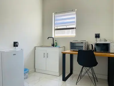 a kitchen with a desk with a computer and a microwave at Maita Corner in Monte Vista