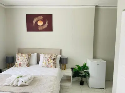 a bedroom with a bed with white sheets and pillows at Maita Corner in Monte Vista