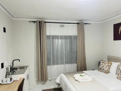 a bedroom with a bed and a sink and a window at Maita Corner in Monte Vista