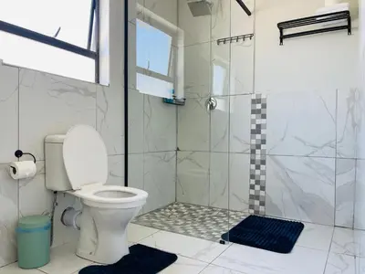 a bathroom with a toilet and a shower at Maita Corner in Monte Vista