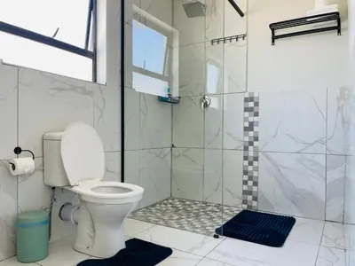 a bathroom with a toilet and a shower at Maita Corner in Monte Vista