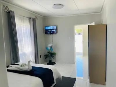 a bedroom with a bed and a tv on the wall at Maita Corner in Monte Vista