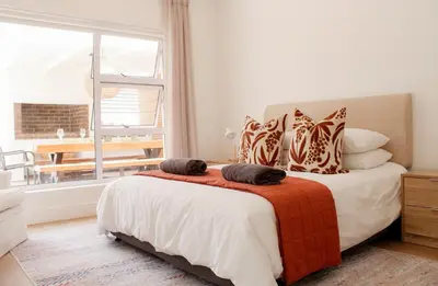 a bedroom with a bed and a large window at Endless summer in Hermanus
