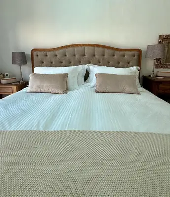 a large bed with two pillows on top of it at Elevené - one bedroom cottage with private pool in Franschhoek
