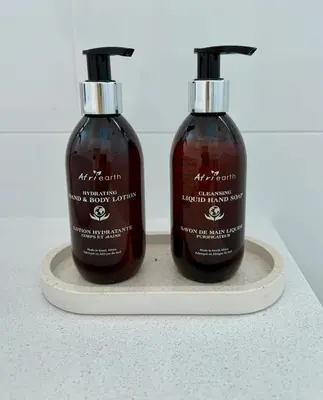 two bottles of hair products sitting on a shelf at Elevené - one bedroom cottage with private pool in Franschhoek