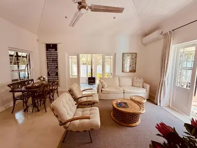 a living room with a couch and a table at Elevené - one bedroom cottage with private pool in Franschhoek