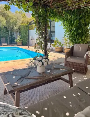 a wooden coffee table in front of a pool at Elevené - one bedroom cottage with private pool in Franschhoek