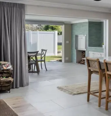a living room with a table and chairs and a kitchen at Sues Suite in Somerset West
