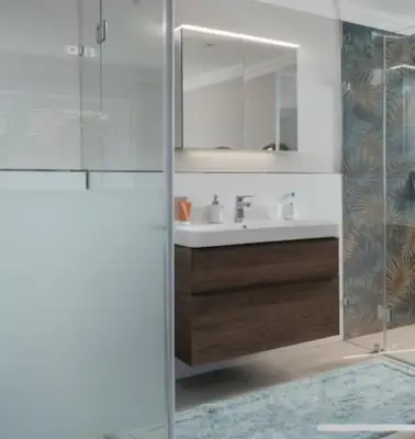a bathroom with a shower and a sink and a mirror at Sues Suite in Somerset West