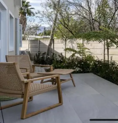 a patio with two chairs and a table at Sues Suite in Somerset West
