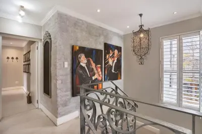 a staircase in a home with paintings on the wall at Avemore Lagratitude no6 - with full backup power in Stellenbosch
