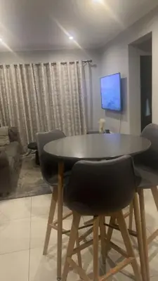 a dining room table and chairs in a living room at Smart and elegant space in Cape Town