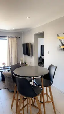 a dining room table and chairs in a living room at Smart and elegant space in Cape Town