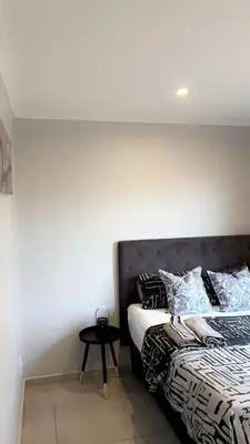 a bedroom with a bed and a table next to it at Smart and elegant space in Cape Town