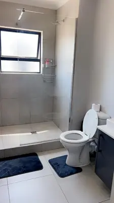 a white bathroom with a toilet and a shower at Smart and elegant space in Cape Town