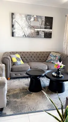 a living room with two tables and a couch at Smart and elegant space in Cape Town