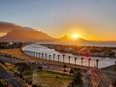 a sunset over a city with a harbor and the ocean at Bird's View in Cape Town