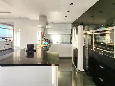 a large kitchen with black and white appliances at Bird's View in Cape Town