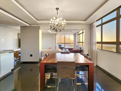 a dining room with a table and a chandelier at Bird's View in Cape Town