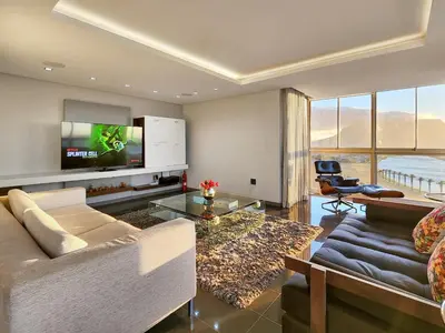 a living room with a couch and a tv at Bird's View in Cape Town