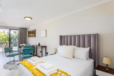 a bedroom with a large bed and a table and chairs at Waterstone A202 by CTHA in Cape Town