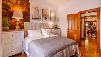 a bedroom with a bed and a dining room at 59 Marine Hermanus in Hermanus