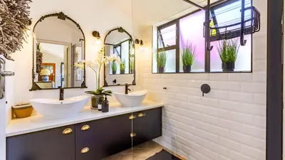 a bathroom with two sinks and two mirrors at 59 Marine Hermanus in Hermanus