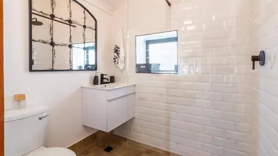 a white bathroom with a toilet and a mirror at 59 Marine Hermanus in Hermanus