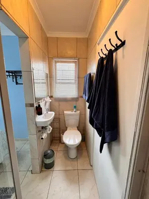 a small bathroom with a toilet and a sink at Sea Breeze in Strand