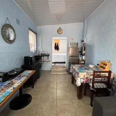 a kitchen with two tables and a refrigerator at Sea Breeze in Strand