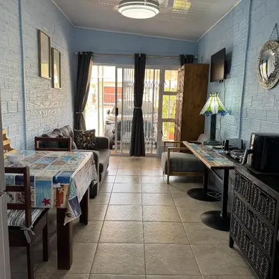 a living room with a bed and a couch at Sea Breeze in Strand