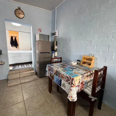 a kitchen with a table and a refrigerator at Sea Breeze in Strand