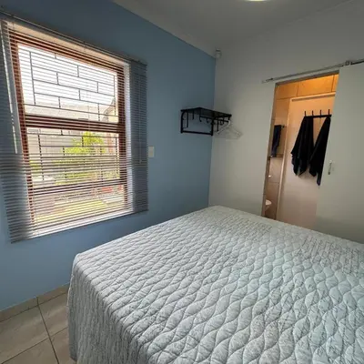 a bedroom with a bed and a window at Sea Breeze in Strand