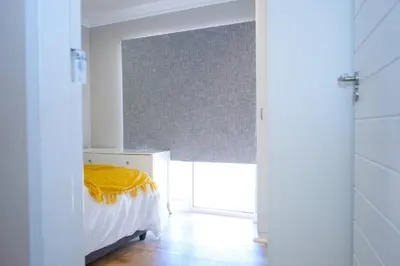 a bedroom with a bed with a yellow blanket on it at 5BR Pool Fast Wi-Fi Walk To The Beach Pool Table in Cape Town