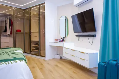 a bedroom with a dresser with a tv and a mirror at 5BR Pool Fast Wi-Fi Walk To The Beach Pool Table in Cape Town