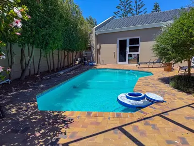 a swimming pool with two inflatable boats in a yard at 5BR Pool Fast Wi-Fi Walk To The Beach Pool Table in Cape Town