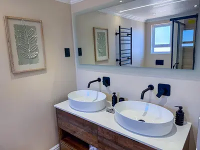 a bathroom with two sinks and a mirror at 5BR Pool Fast Wi-Fi Walk To The Beach Pool Table in Cape Town