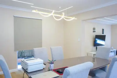 a conference room with a table and chairs and a projector at 5BR Pool Fast Wi-Fi Walk To The Beach Pool Table in Cape Town