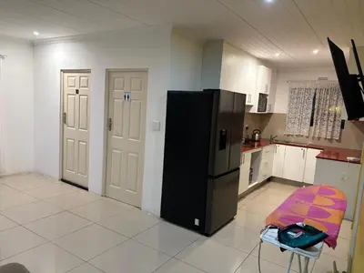 a kitchen with a black refrigerator and a chair in it at SNE Travellers in Faure
