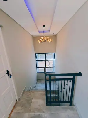 a hallway with a black chair and a chandelier at Beachwalk luxury one bedroom apartments in Cape Town