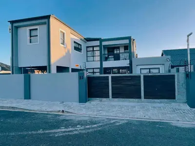 a house with a gate in front of it at Beachwalk luxury one bedroom apartments in Cape Town