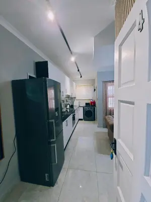 a kitchen with a black refrigerator in a room at Beachwalk luxury one bedroom apartments in Cape Town