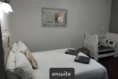 a bedroom with a bed with a mirror and a chair at strand Holiday House in Strand
