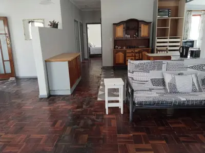 a living room with two couches and a kitchen at strand Holiday House in Strand