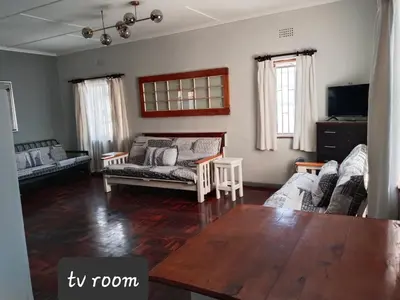 a living room with a couch and a table at strand Holiday House in Strand